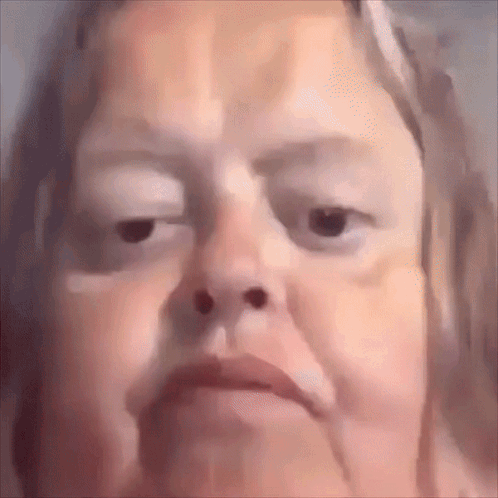 A Close Up Of A Woman 'S Face With A Very Serious Look On Her Face . GIF