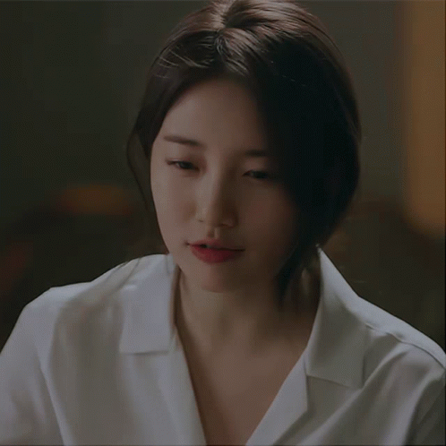 A Close Up Of A Woman 'S Face With A White Shirt GIF