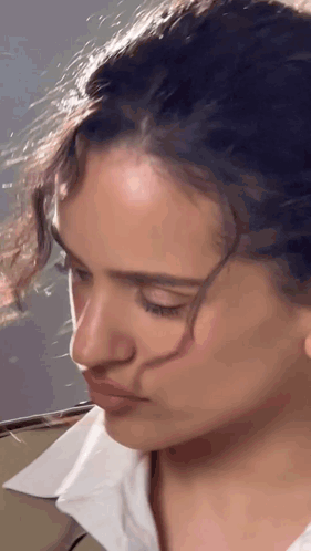 A Close Up Of A Woman 'S Face With A White Shirt GIF