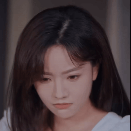 A Close Up Of A Woman 'S Face With A White Shirt On . GIF
