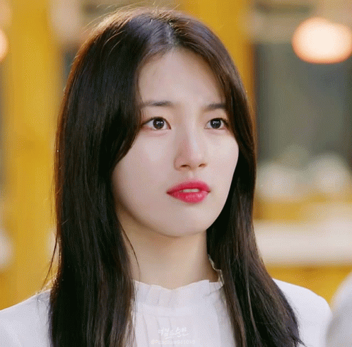 A Close Up Of A Woman 'S Face With A Yellow Background And A Watermark That Says ' Korean ' On It GIF