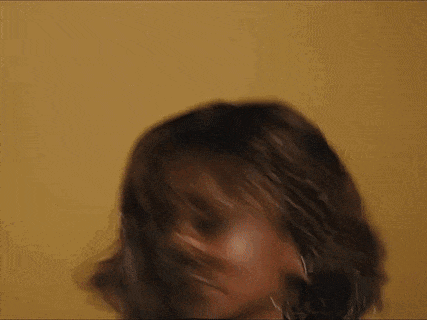 A Close Up Of A Woman 'S Face With A Yellow Background . GIF