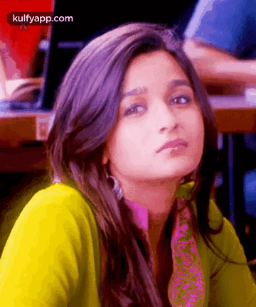 A Close Up Of A Woman 'S Face With A Yellow Shirt And A Pink Scarf . GIF