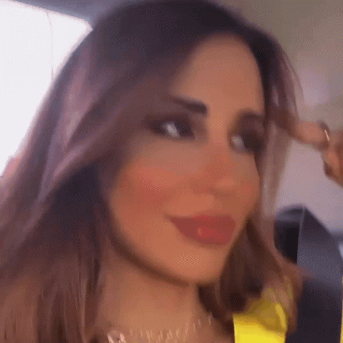 A Close Up Of A Woman 'S Face With A Yellow Top On GIF
