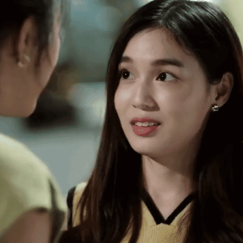 A Close Up Of A Woman 'S Face With A Yellow Top On GIF