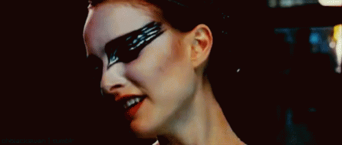 A Close Up Of A Woman 'S Face With Black Feathers Painted On Her Face . GIF