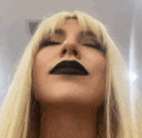 A Close Up Of A Woman 'S Face With Black Lips . GIF