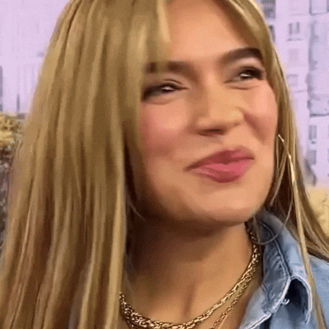 A Close Up Of A Woman 'S Face With Blonde Hair And A Gold Necklace GIF