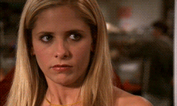 a close up of a woman 's face with blonde hair and a yellow necklace