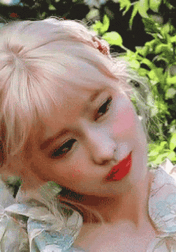 A Close Up Of A Woman 'S Face With Blonde Hair And Red Lips . GIF