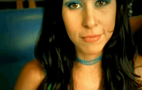 A Close Up Of A Woman 'S Face With Blue Eye Shadow GIF