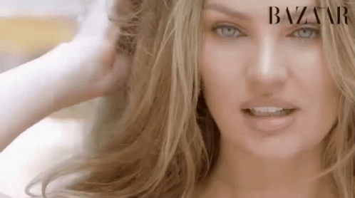 A Close Up Of A Woman 'S Face With Blue Eyes And Blonde Hair . GIF