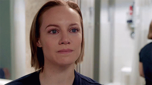 A Close Up Of A Woman 'S Face With Blue Eyes And Short Hair . GIF