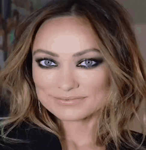 A Close Up Of A Woman 'S Face With Blue Eyes . GIF