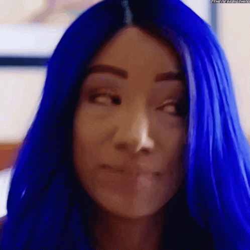 A Close Up Of A Woman 'S Face With Blue Hair GIF