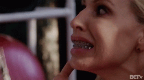 A Close Up Of A Woman 'S Face With Braces On Her Teeth And A Bet Logo In The Corner GIF