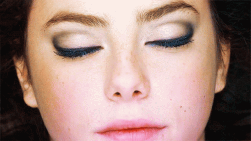 A Close Up Of A Woman 'S Face With Closed Eyes GIF