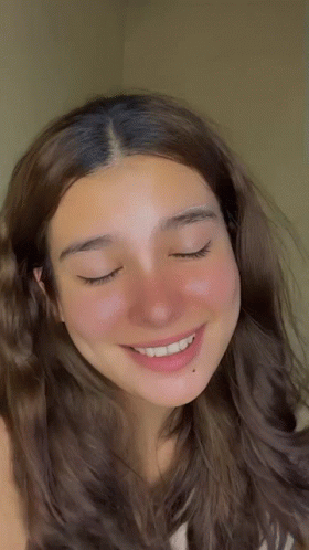 A Close Up Of A Woman 'S Face With Closed Eyes GIF