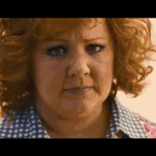 A Close Up Of A Woman 'S Face With Curly Red Hair . GIF