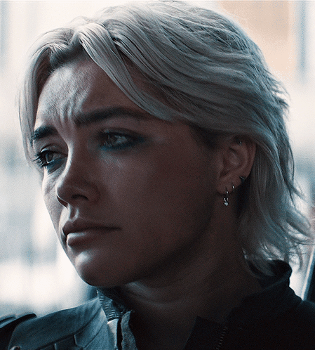 A Close Up Of A Woman 'S Face With Earrings On GIF