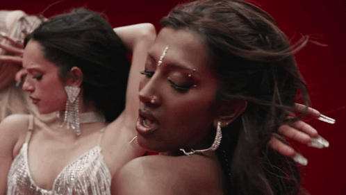 A Close Up Of A Woman 'S Face With Earrings On GIF