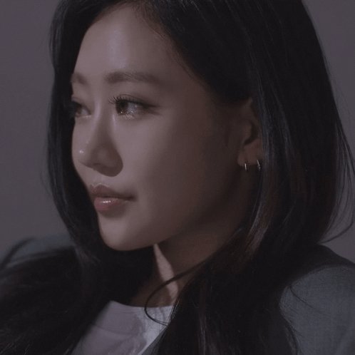 A Close Up Of A Woman 'S Face With Earrings GIF