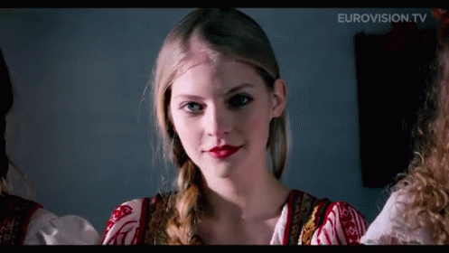 A Close Up Of A Woman 'S Face With Eurovision.tv In The Upper Right Corner GIF