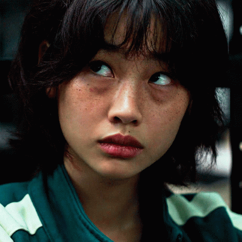 A Close Up Of A Woman 'S Face With Freckles And A Green And White Striped Shirt GIF