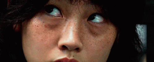 A Close Up Of A Woman 'S Face With Freckles And A Serious Look On Her Face . GIF