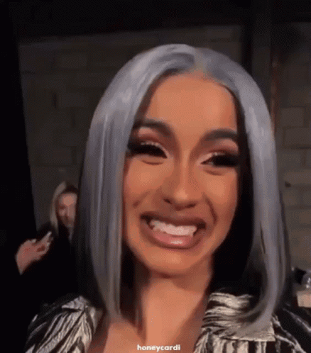 A Close Up Of A Woman 'S Face With Gray Hair And A Smile . GIF