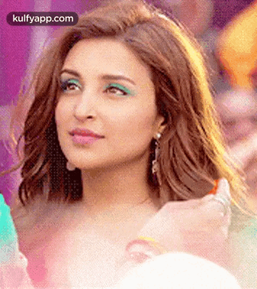 A Close Up Of A Woman 'S Face With Green Eye Shadow And Earrings . GIF