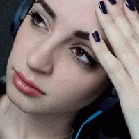 A Close Up Of A Woman 'S Face With Headphones On GIF