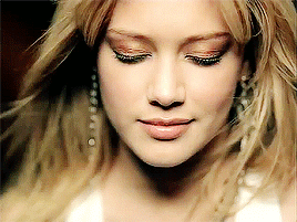 A Close Up Of A Woman 'S Face With Her Eyes Closed And Her Hair Blowing In The Wind GIF