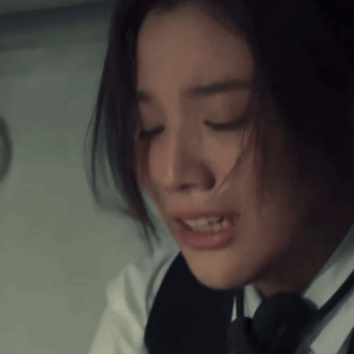A Close Up Of A Woman 'S Face With Her Eyes Closed And Her Hair Blowing In The Wind GIF