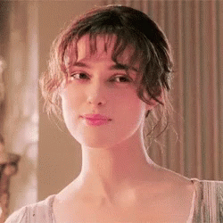 A Close Up Of A Woman 'S Face With Her Eyes Closed And Her Hair In A Bun . GIF