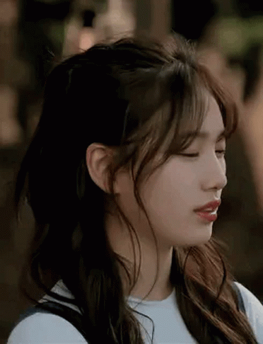 A Close Up Of A Woman 'S Face With Her Eyes Closed And Her Hair In A Half Up Half Down Hairstyle . GIF