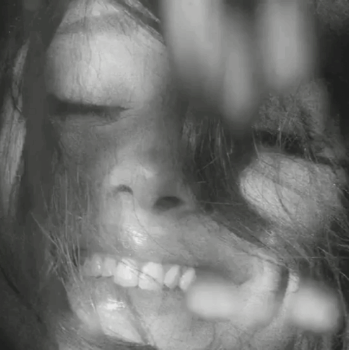 A Close Up Of A Woman 'S Face With Her Eyes Closed And Her Mouth Open . GIF