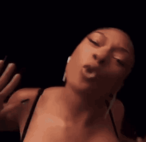 A Close Up Of A Woman 'S Face With Her Eyes Closed And Her Mouth Open In A Dark Room . GIF