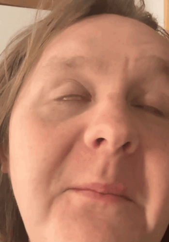 A Close Up Of A Woman 'S Face With Her Eyes Closed And Her Mouth Open GIF