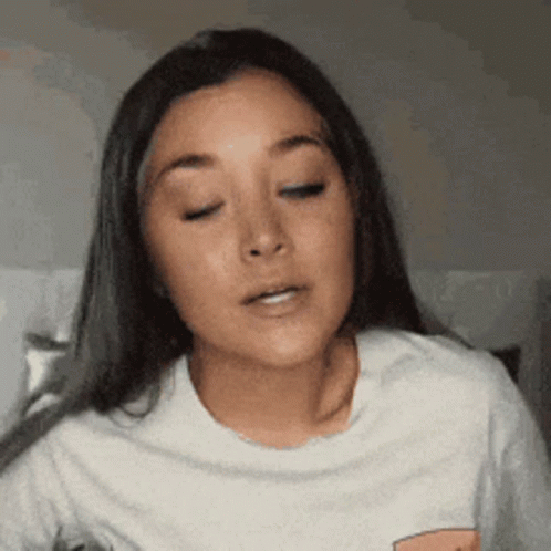 A Close Up Of A Woman 'S Face With Her Eyes Closed And Her Mouth Open . GIF