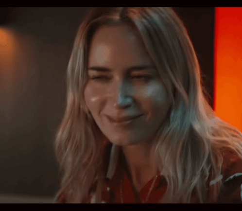 A Close Up Of A Woman 'S Face With Her Eyes Closed And Smiling GIF