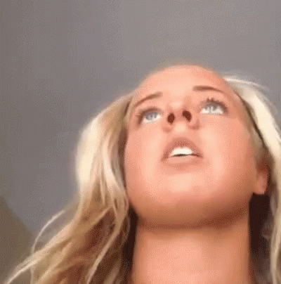 A Close Up Of A Woman 'S Face With Her Eyes Closed Looking Up . GIF