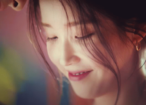 a close up of a woman 's face with her eyes closed smiling