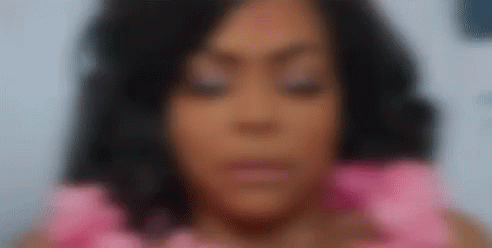 A Close Up Of A Woman 'S Face With Her Eyes Closed Wearing A Pink Dress . GIF