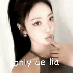 A Close Up Of A Woman 'S Face With Her Finger In Her Mouth . GIF