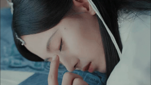 A Close Up Of A Woman 'S Face With Her Finger On Her Eye GIF