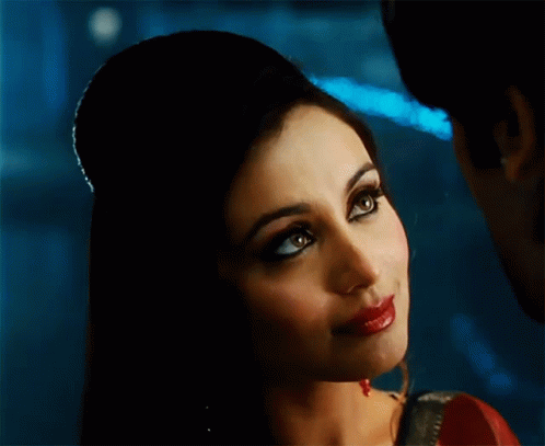 A Close Up Of A Woman 'S Face With Her Hair In A Bun GIF