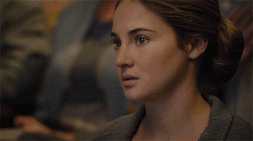 A Close Up Of A Woman 'S Face With Her Hair In A Bun GIF