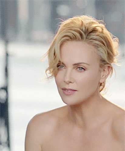 A Close Up Of A Woman 'S Face With Her Hair In A Bun GIF