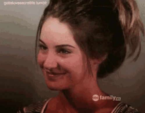 A Close Up Of A Woman 'S Face With Her Hair In A Ponytail GIF